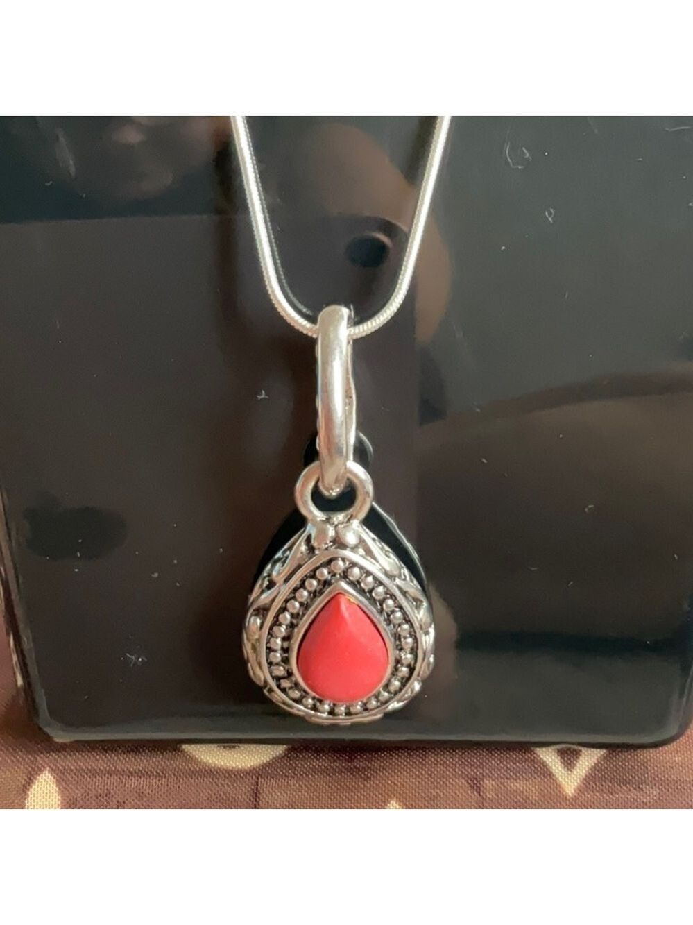 Embossed silver tone vintage pendent with coral center